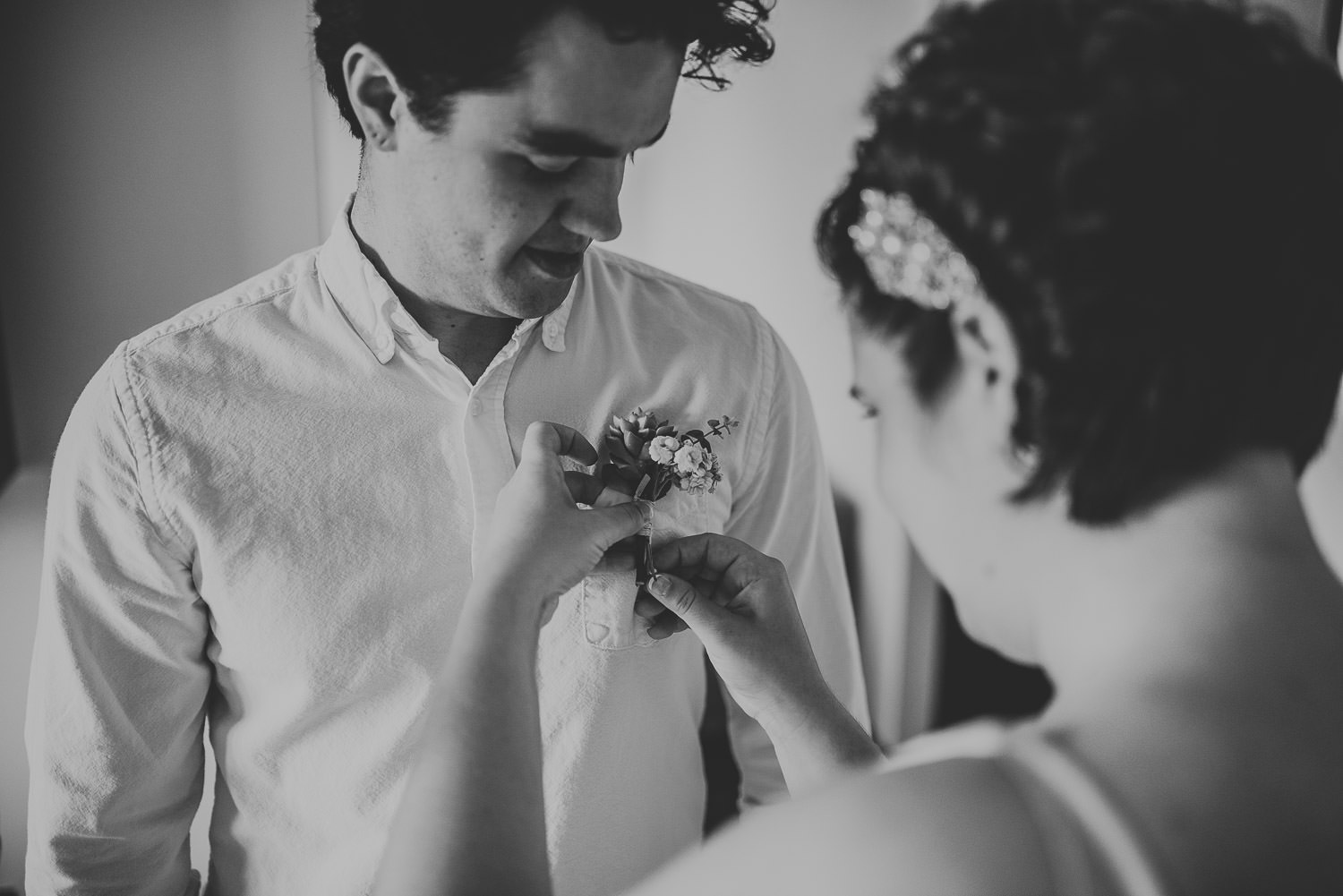 bride helps brother with his buttonhole