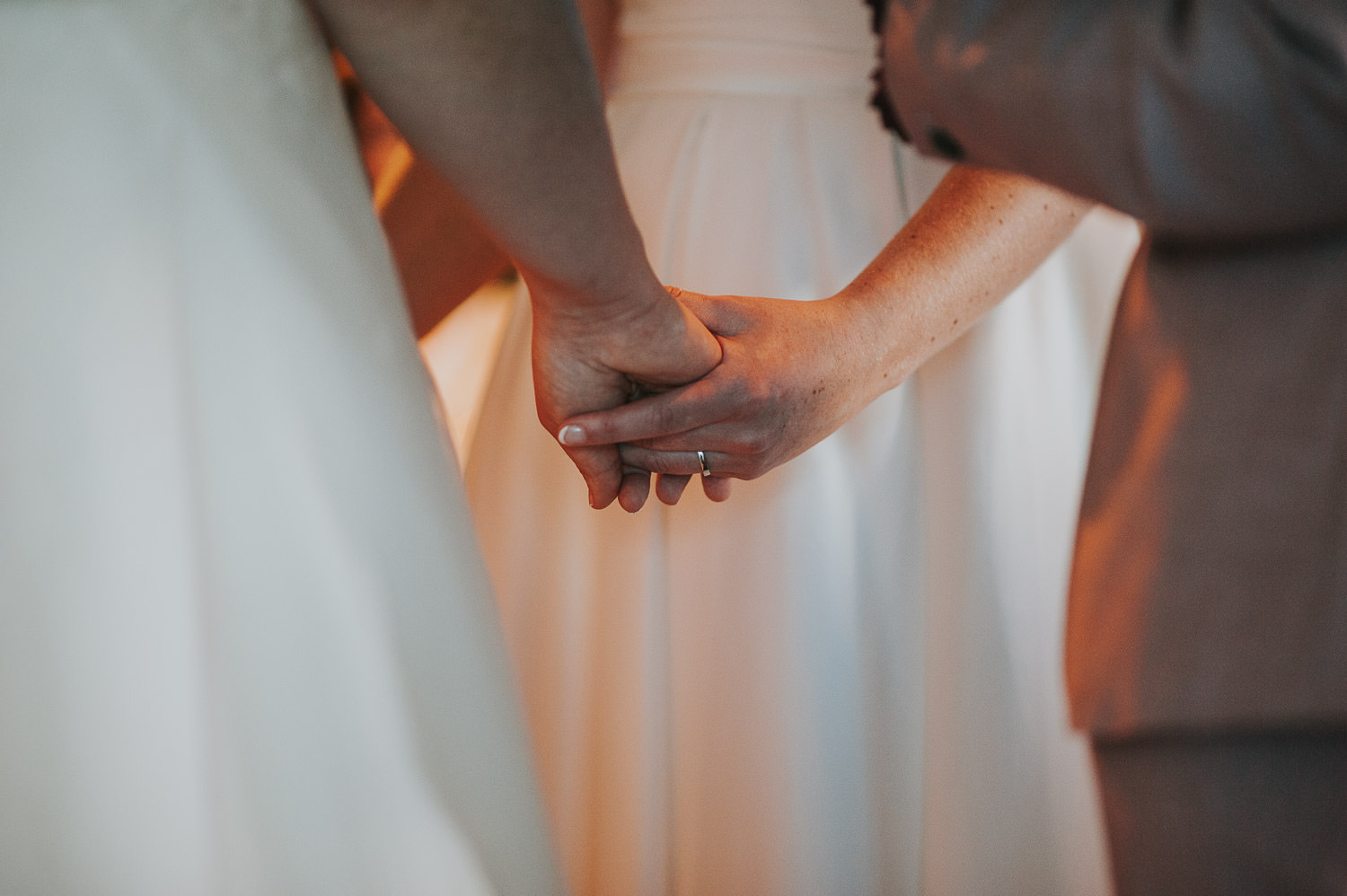 closeup of brides holding hands