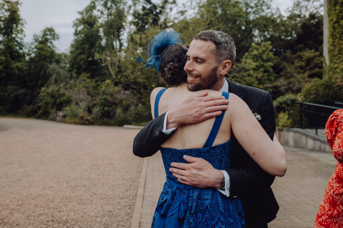 Groom hugging a wedding guest