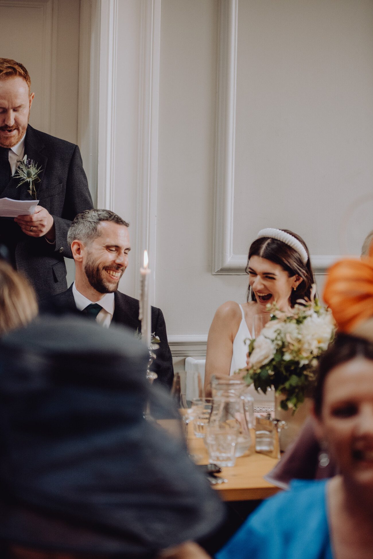 Bride and groom laughing during wedding speeches